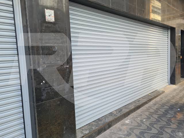 Porta de aço de enrolar instalada em fachada comercial